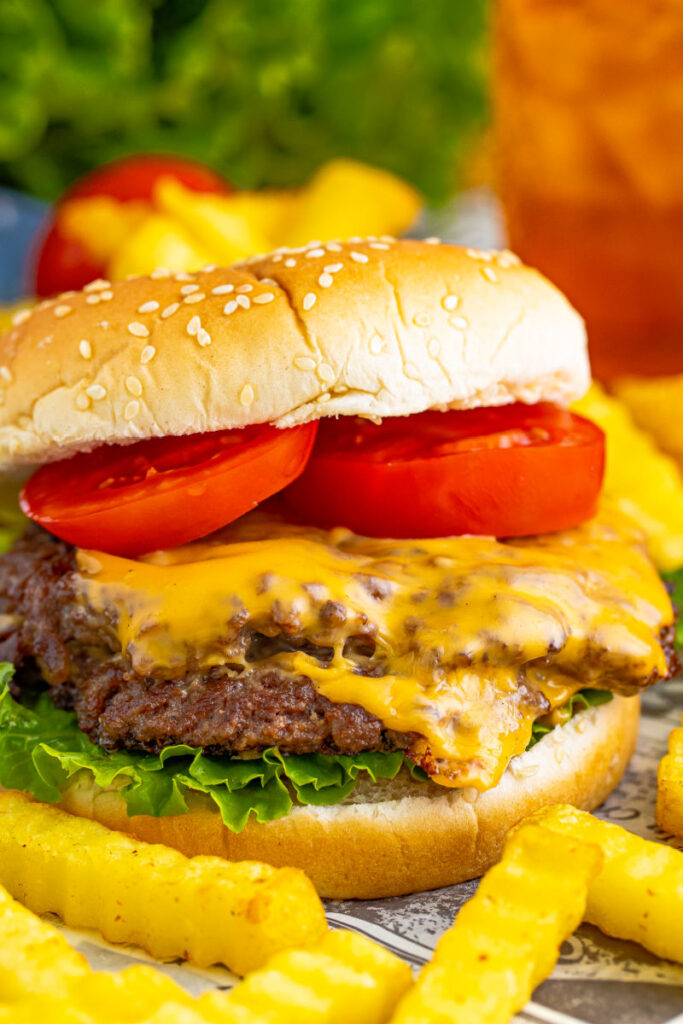 side view of a smash burger next to french fries