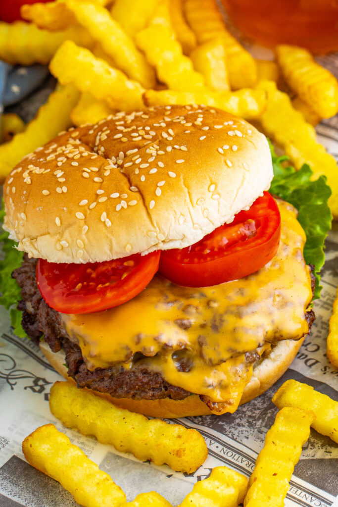 close up of a smash burger topped with lettuce and tomato