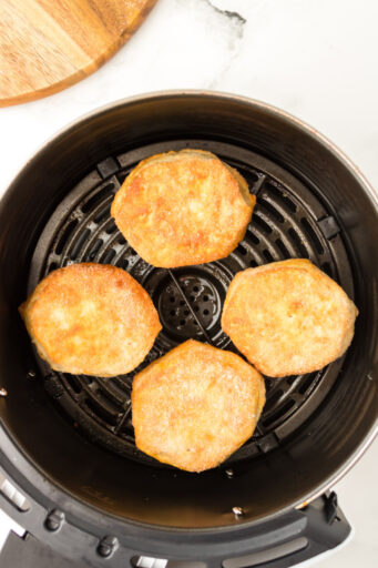 cooked sugared biscuits in an air fryer basket after cooking