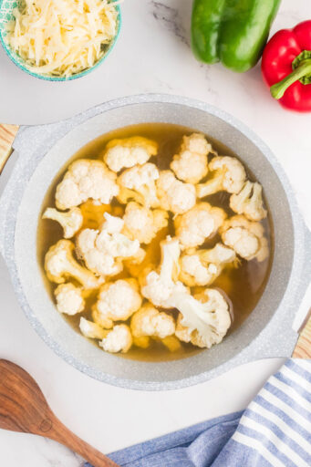 cauliflower florets in a pot with vegetable broth and water