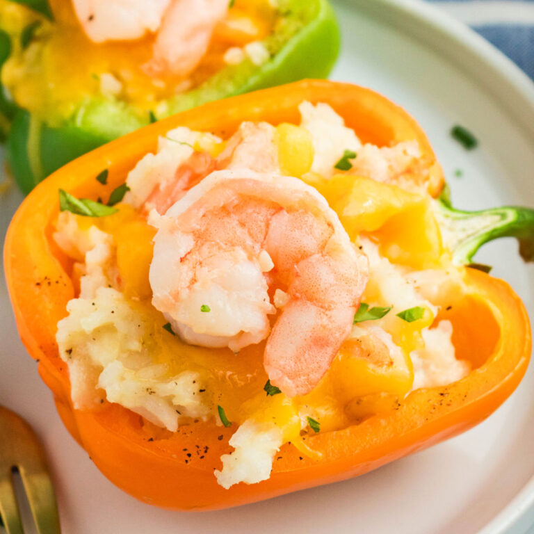square image of shrimp stuffed peppers on a dinner plate with a fork