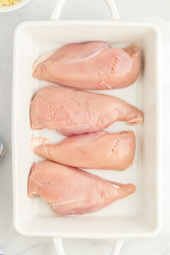 chicken breasts lined up in a baking dish