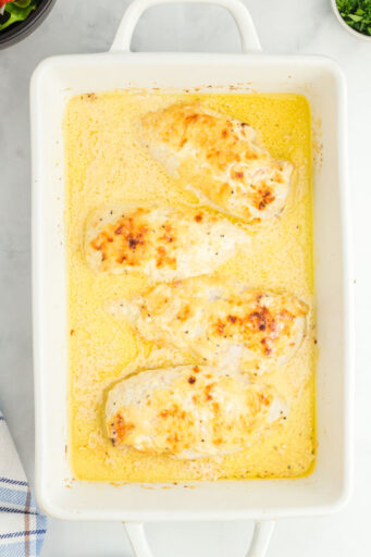 broiled baked caesar chicken in a white baking dish