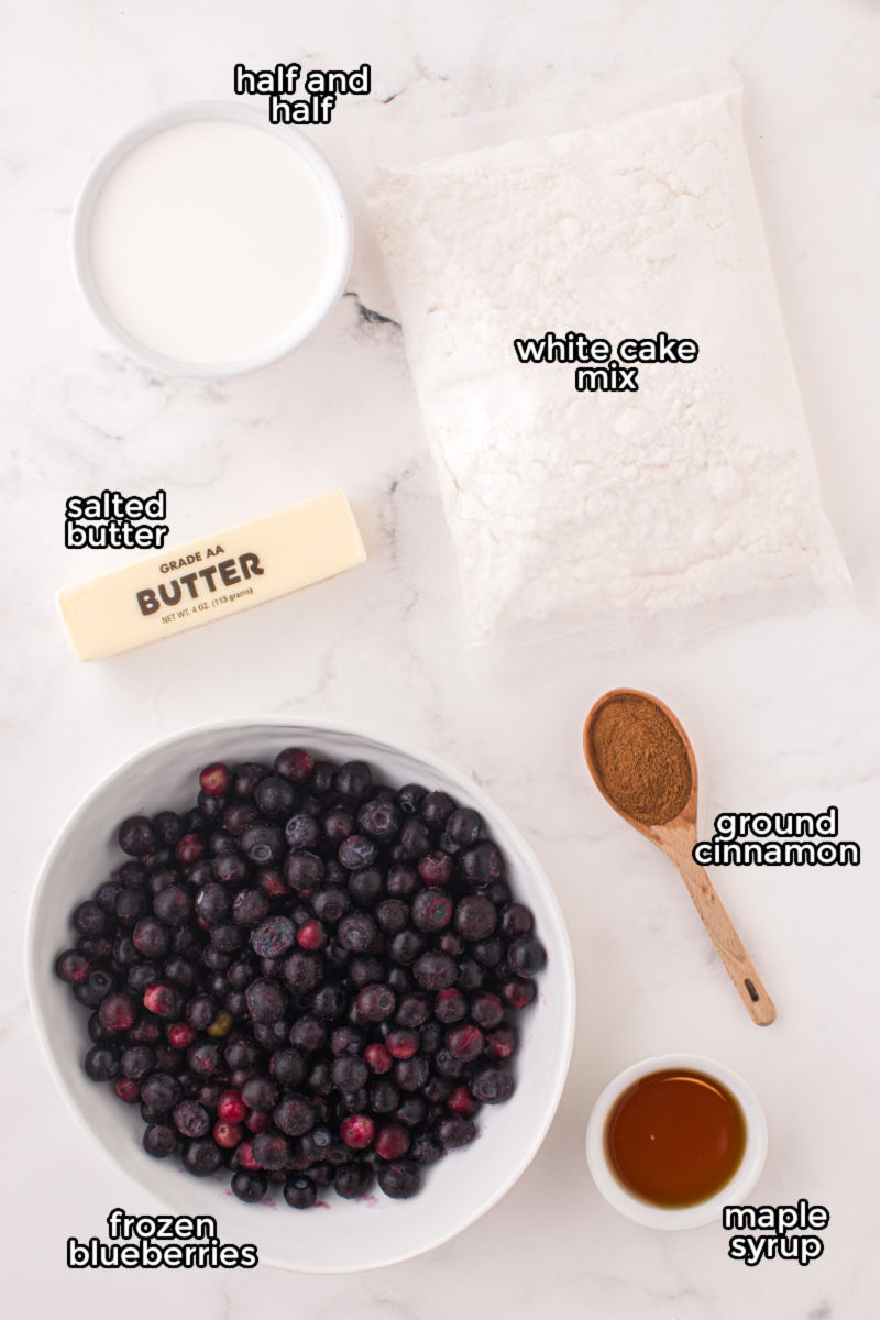ingredients to make blueberry cobbler laid out on a counter with text labels
