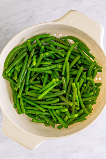 trimmed and boiled green beans in a colander