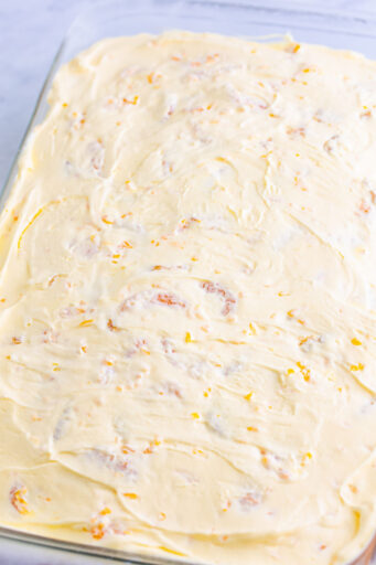 orange vanilla mousse topping spread over the cooled poke cake