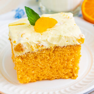 square image of orange creamsicle cake with orange and mint garnish