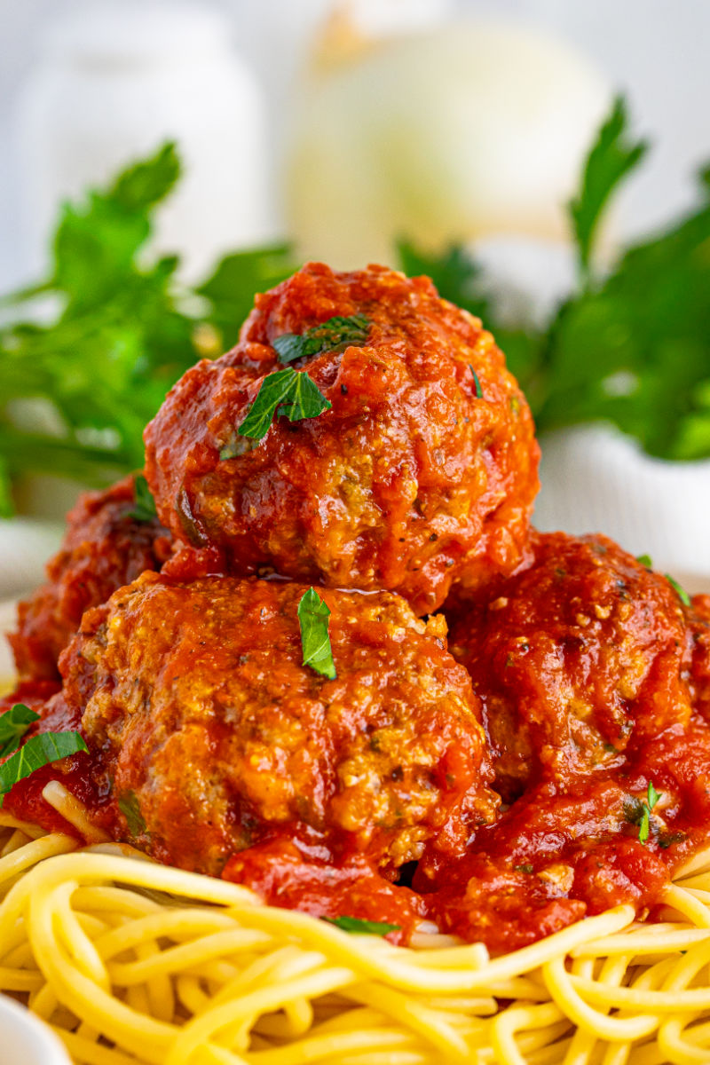 close up of italian meatballs in marinara served over pasta