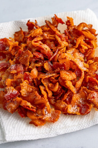 cooked diced bacon on a paper towel-lined plate