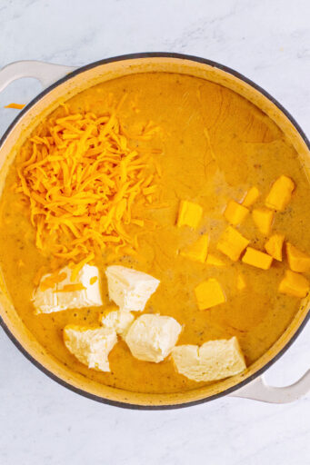 cream cheese, Velveeta, and cheddar added to a pot of cheeseburger soup base after simmering