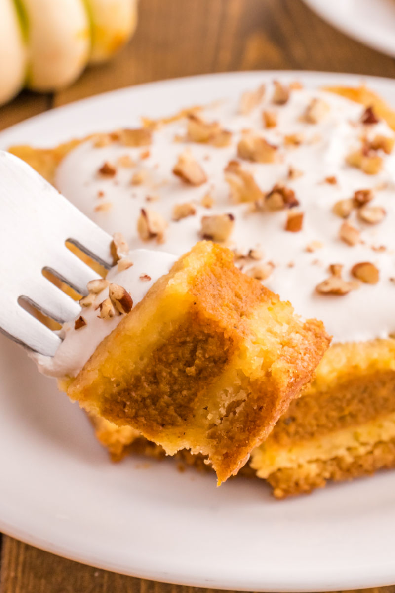 bite of pumpkin pie cake on a fork over the plate